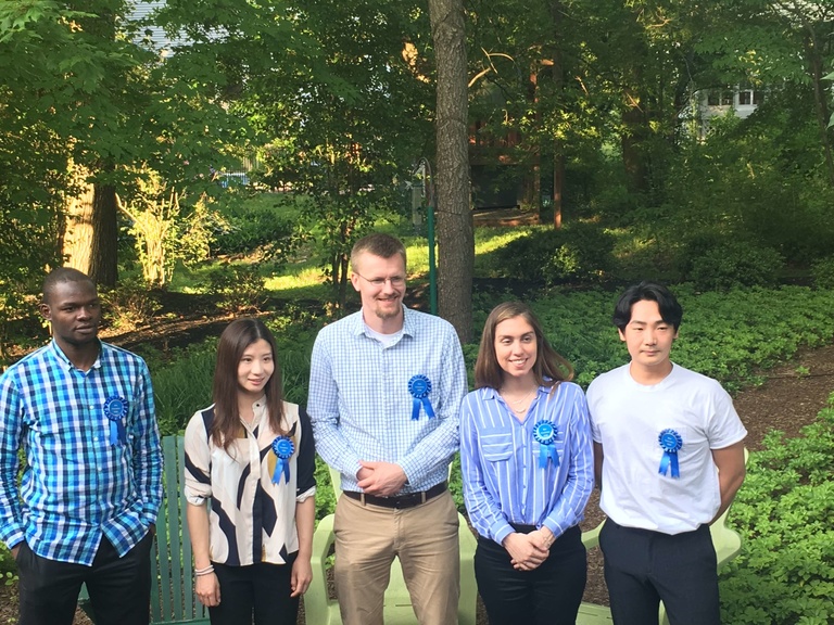 5 people outside wearing a blue ribbon attached to their shirts