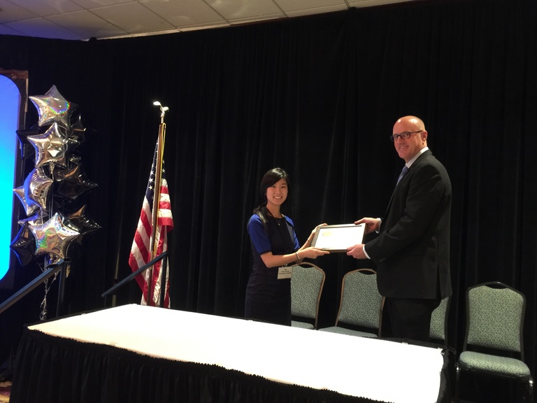 A student, Haena Kim, receiving a plaque from Executive Vice President Bill Rosenerdent